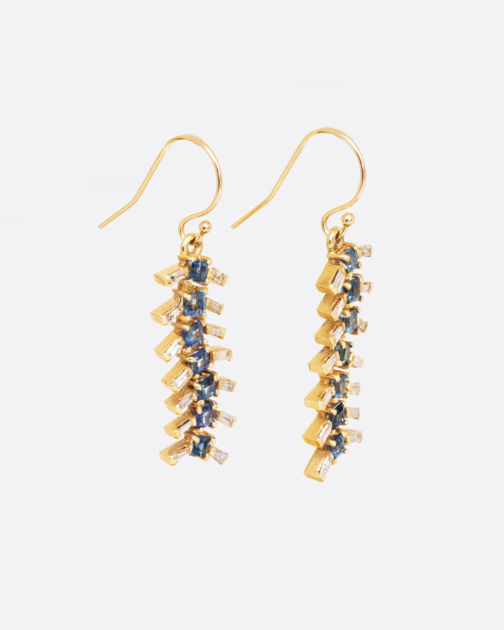 14k yellow gold centipede earrings with blue sapphire and diamond baguettes, shown from the side.