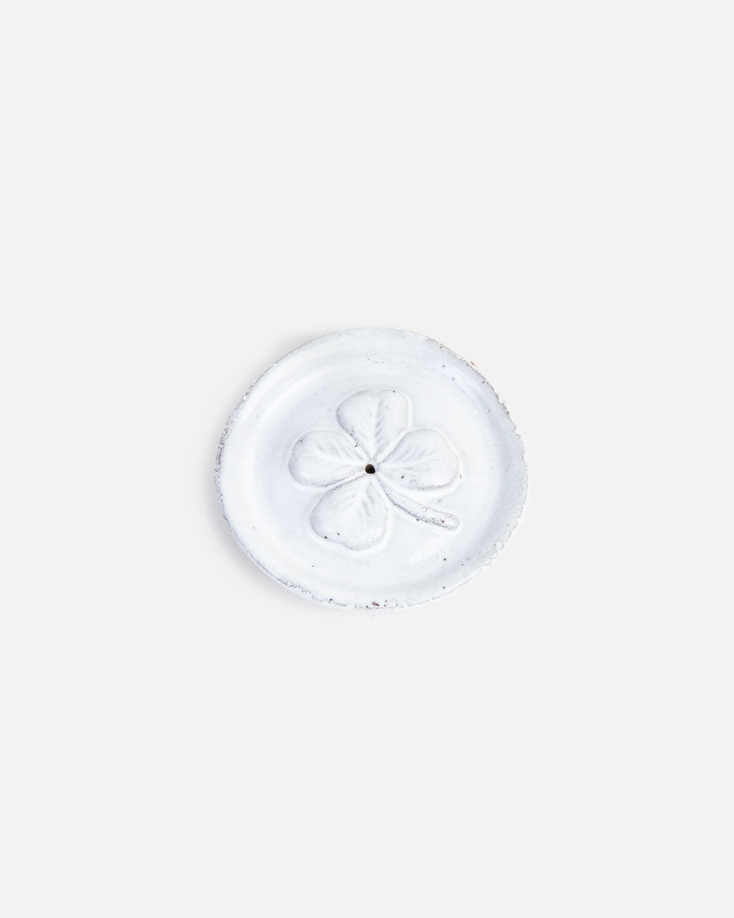 round white incense burner with a four leaf clover pattern on the face
