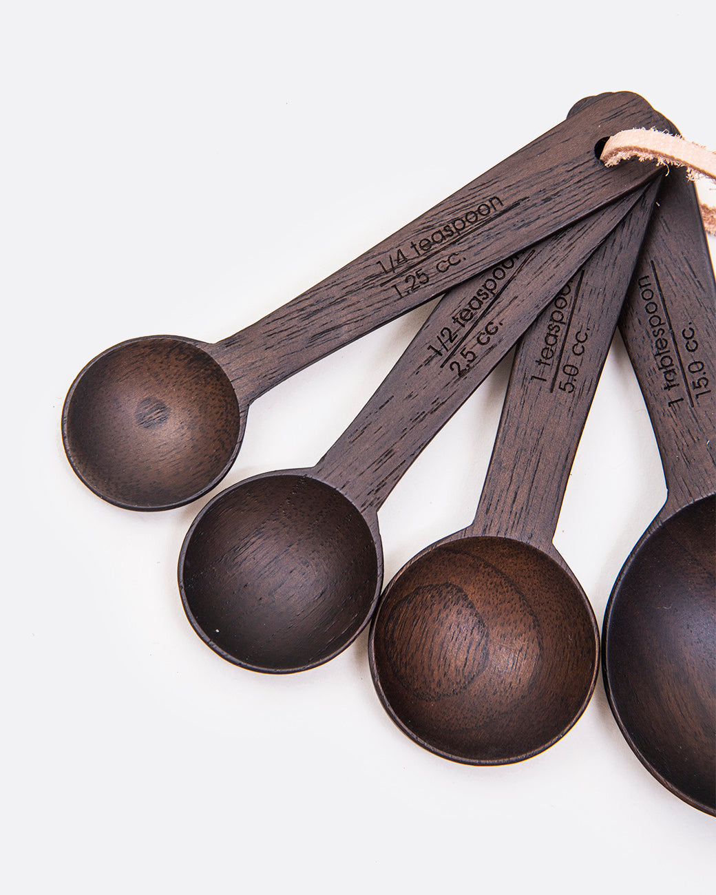 above view of dark wood measuring spoons side by side with the writing etched into the handles
