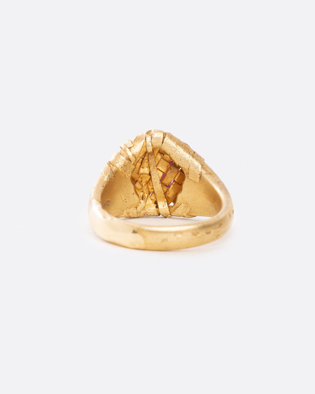 rear view of yellow gold ring with a ruby wrapped in yellow gold on a flat signet band.