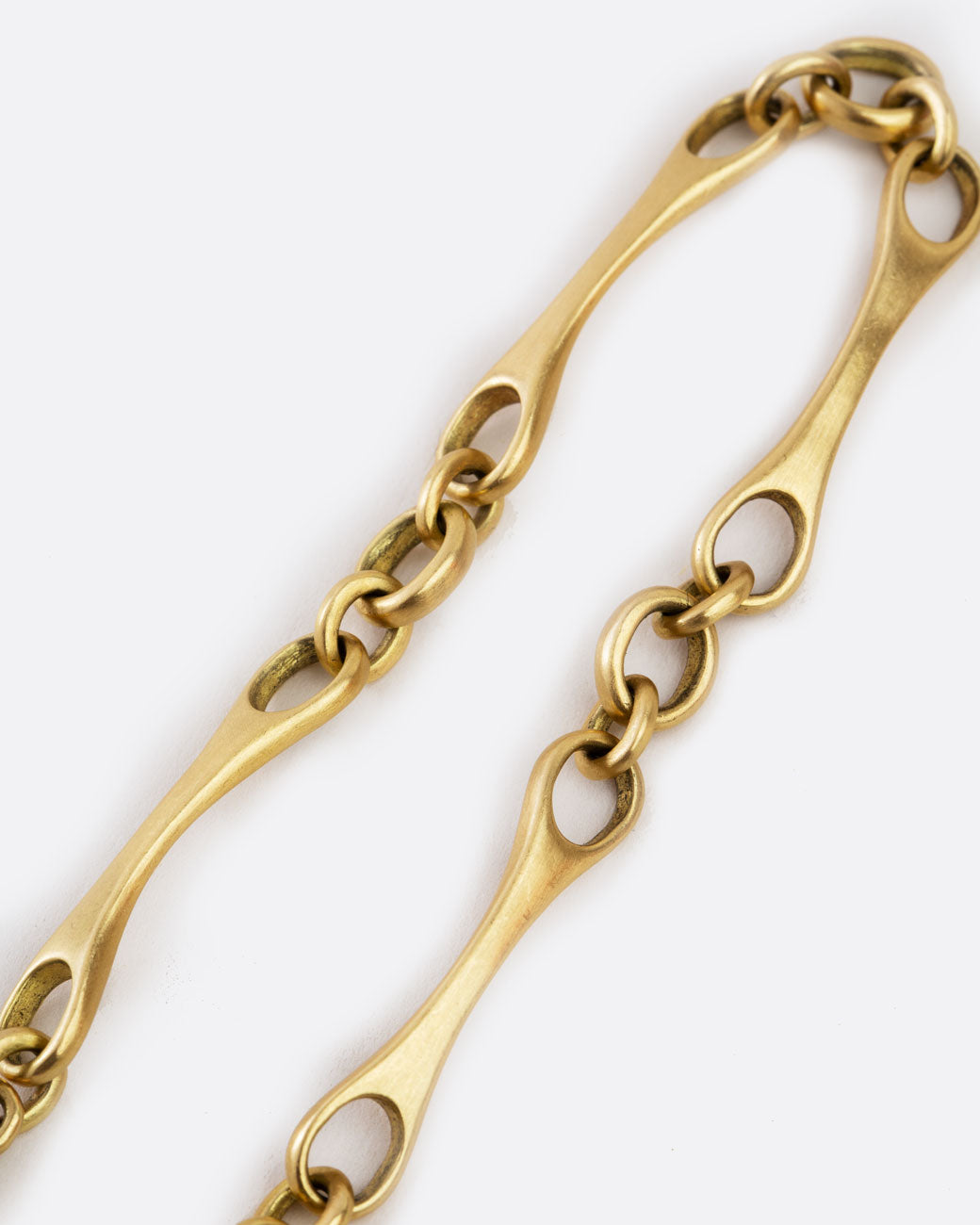 close up of bracelet made of four matte brushed yellow gold long links