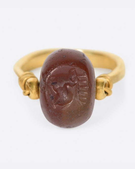 yellow gold ring with a carnelian stone that flips over and a stag carved into it