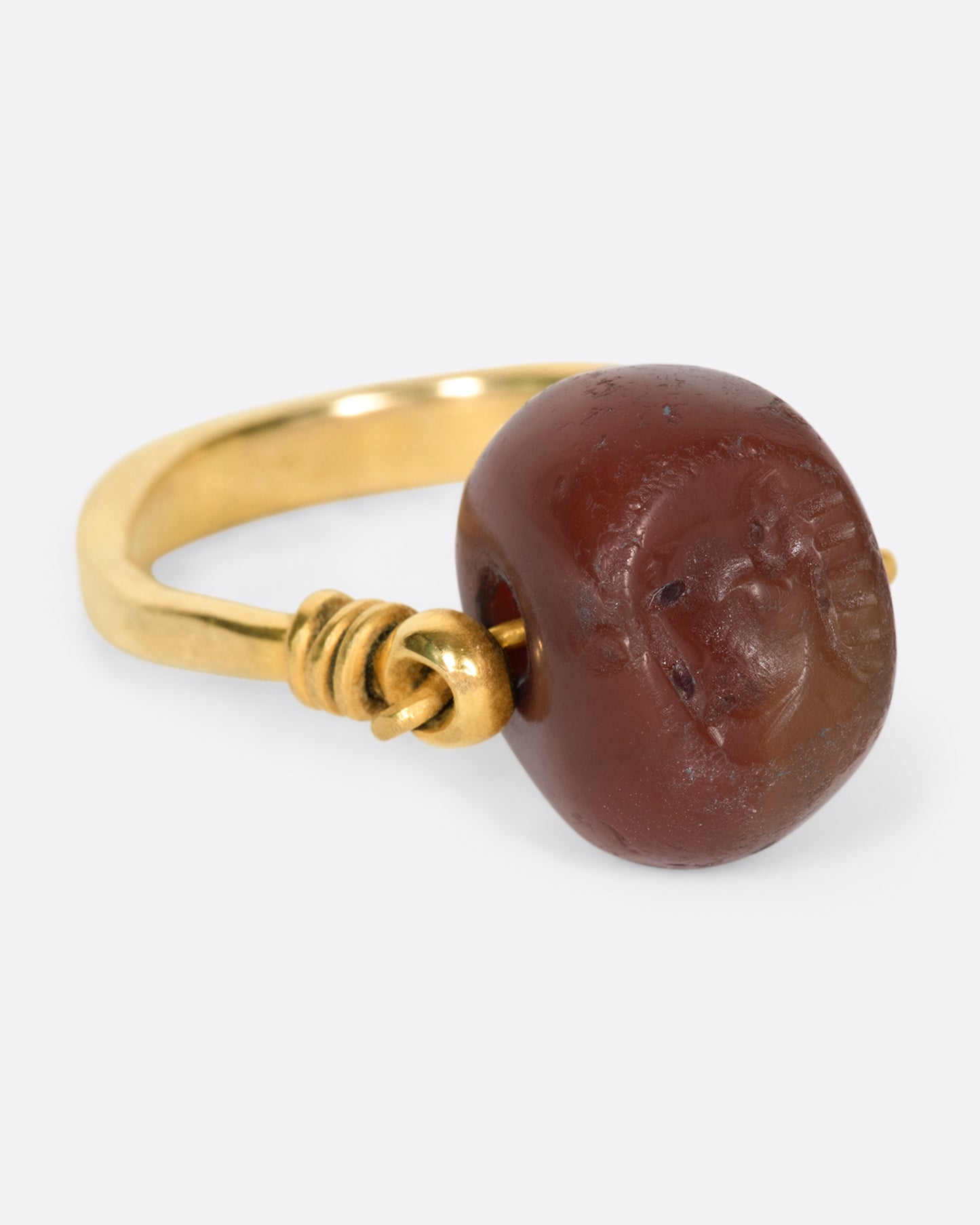 yellow gold ring with a carnelian stone that flips over and a stag carved into it