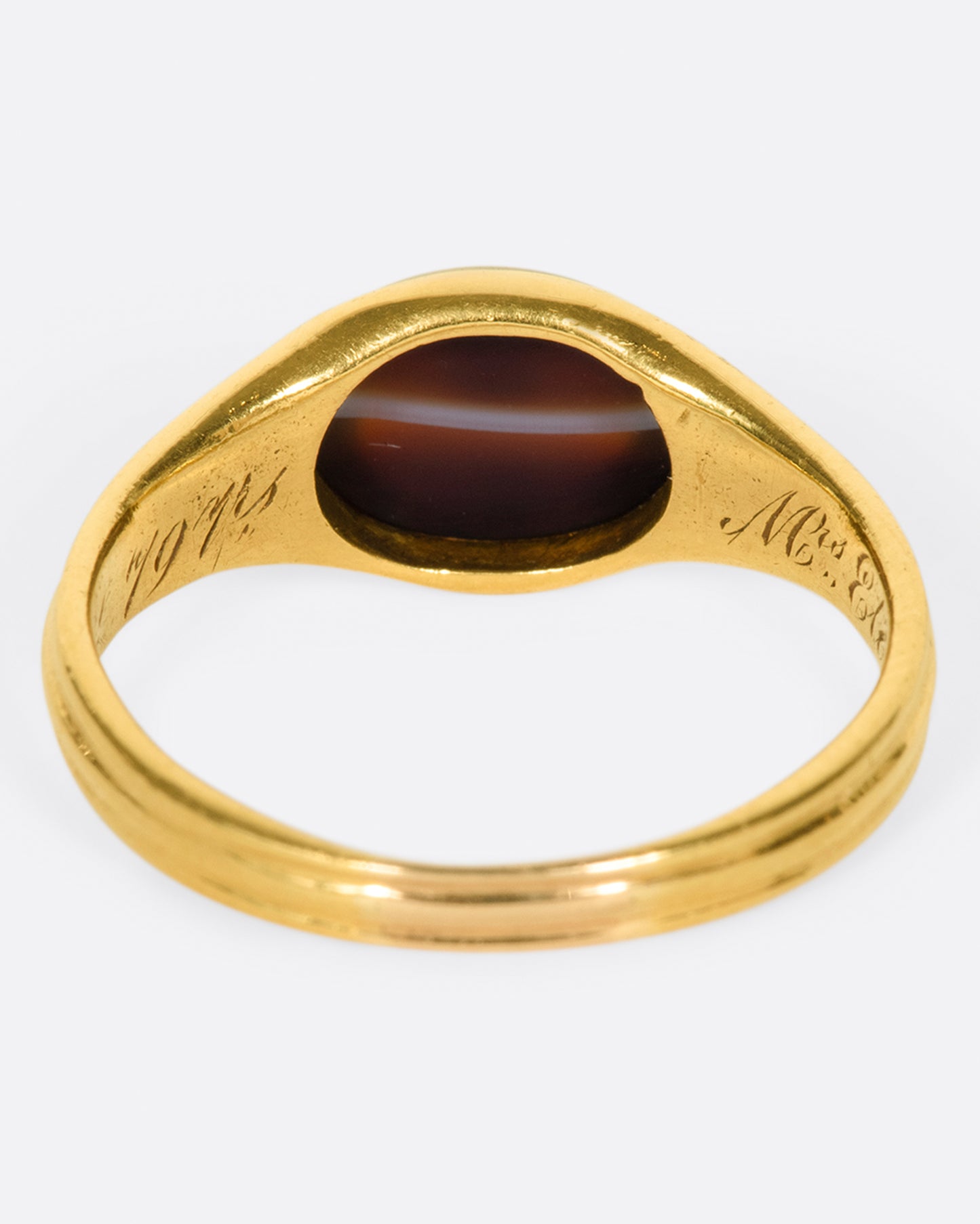 A vintage gold signet ring with a banded deep red oval agate at its center.