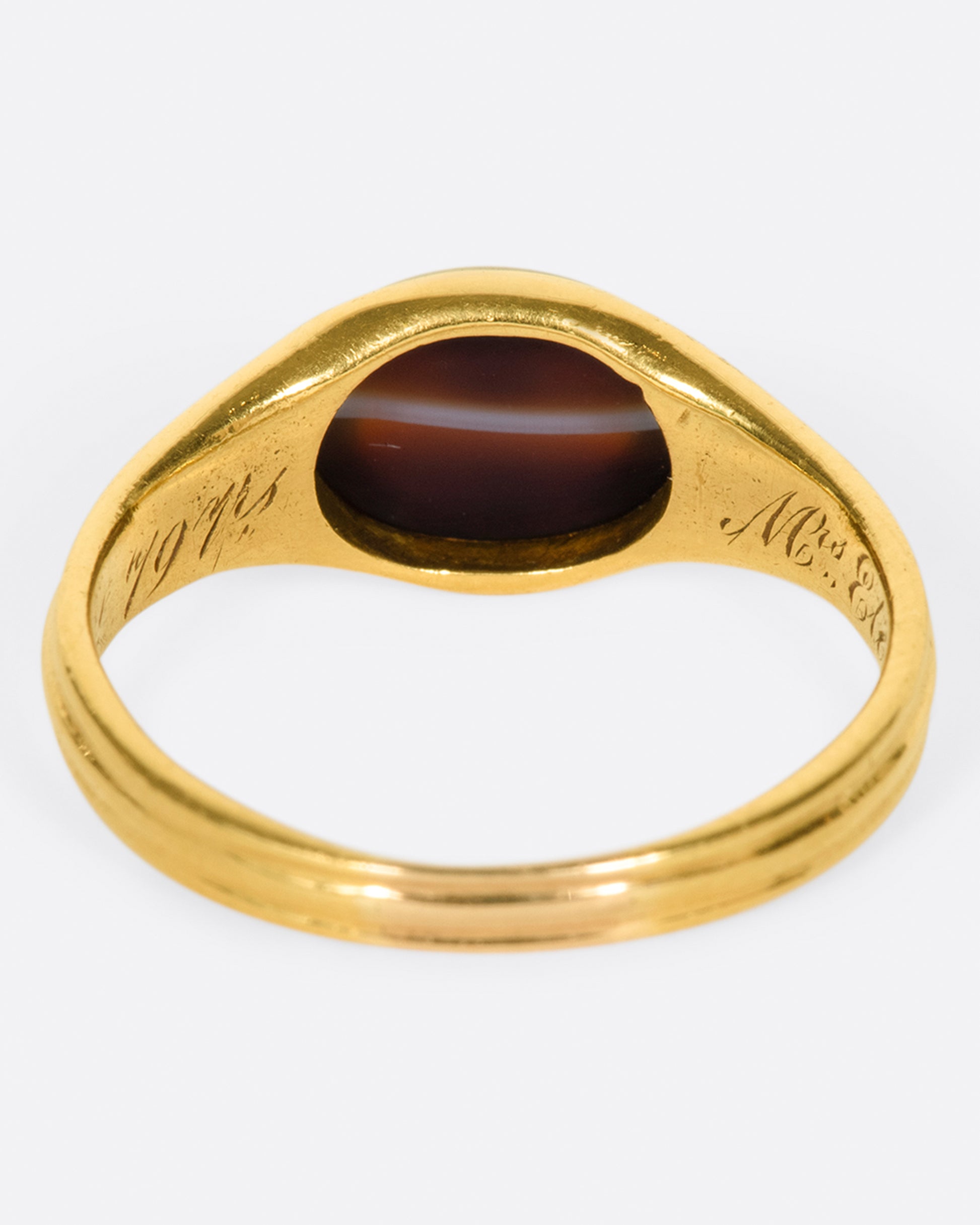 A vintage gold signet ring with a banded deep red oval agate at its center.