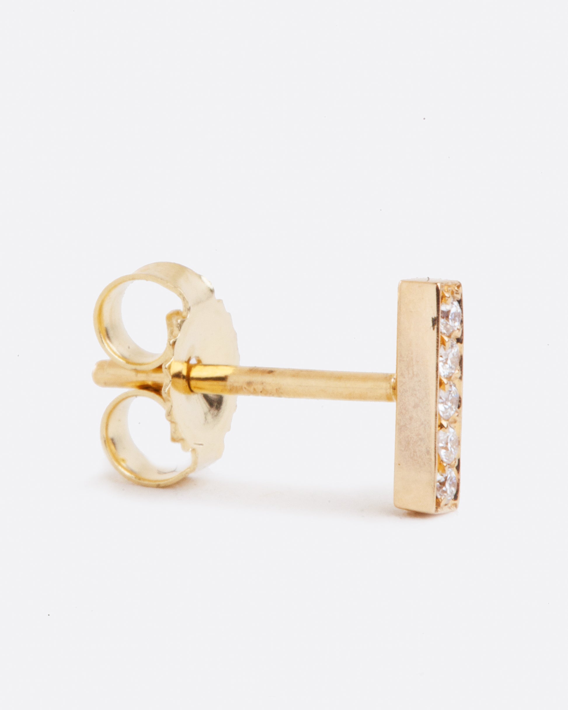 14k yellow gold bar stud earring with five white diamonds by Selin Kent, shown from the side.