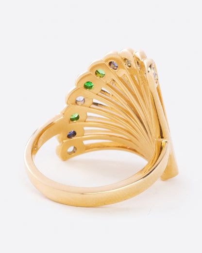 A yellow gold ring in the shape of a fan with multicolor sapphires along the top edge. Shown from the back. 
