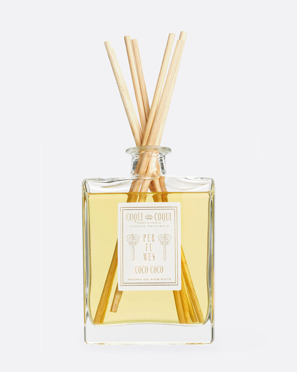 image of coqui coqui reed diffuser - a glass bottle with wooden sticks out the top