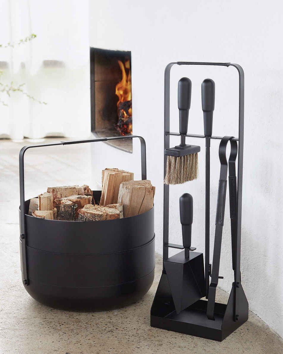 two black colored fire place items. one is a basket, the other is a stand with four tool on it. all have black leather details on the handles.