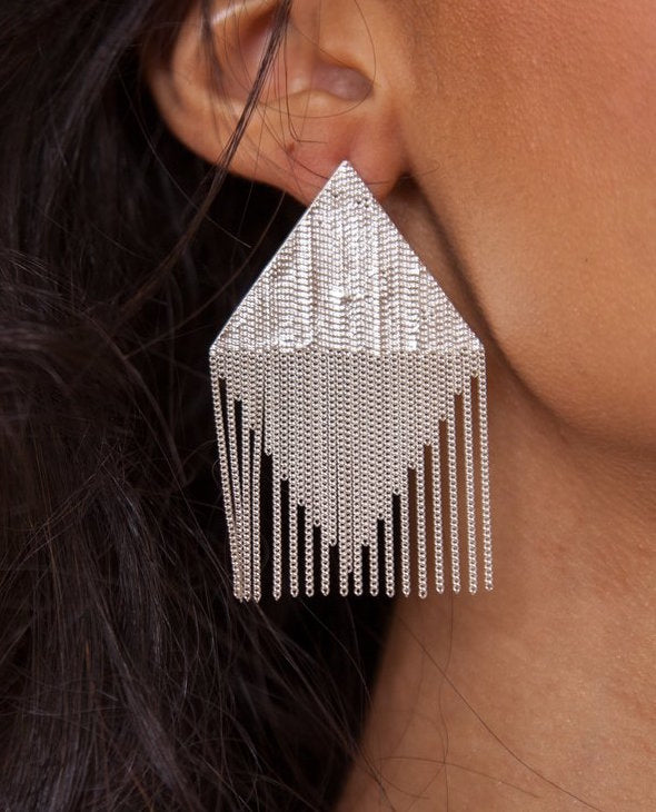 hannah keefe silver and chain tent earring on an ear, it extends past her jawline