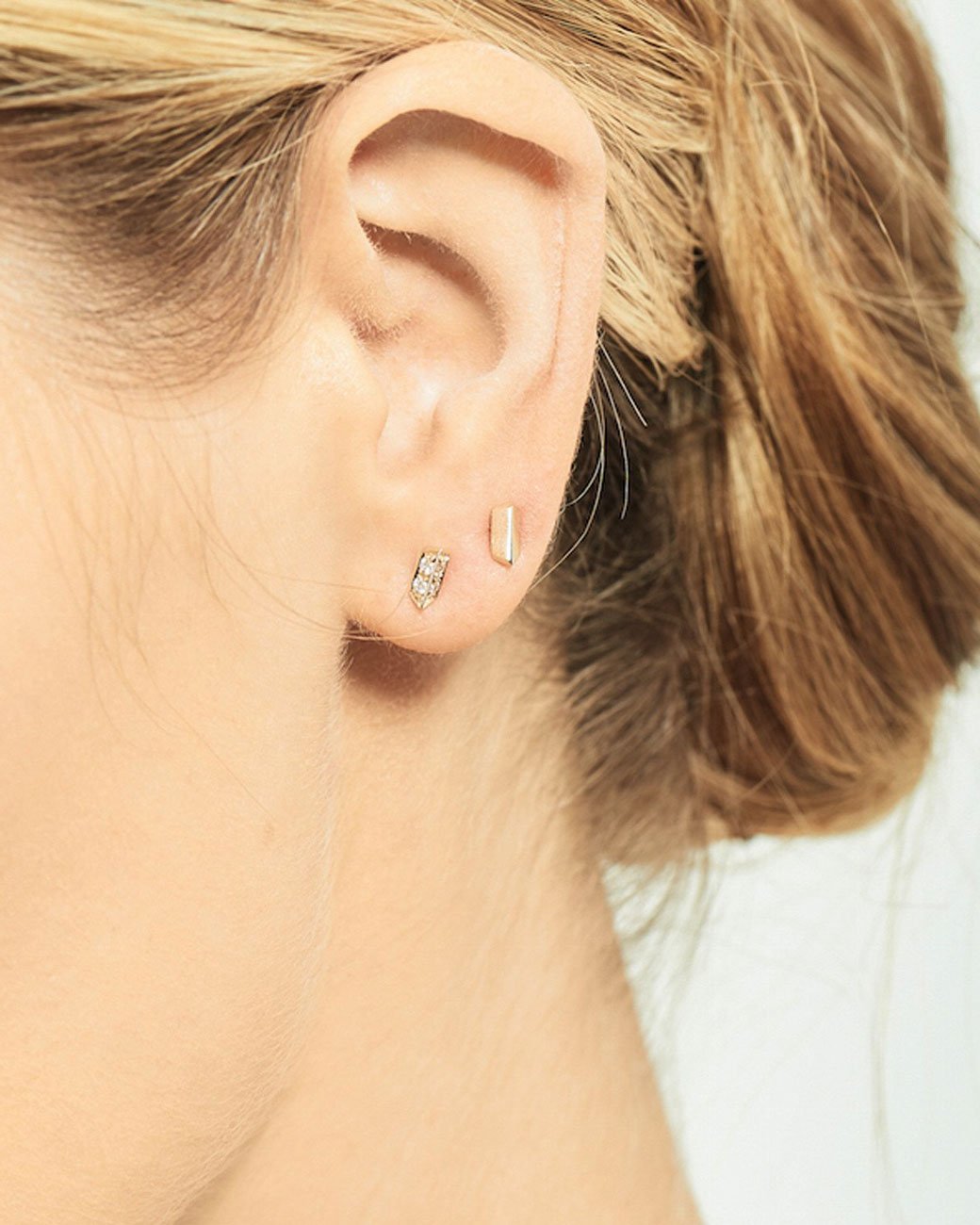 14k rose gold angled bar stud earring by Selin Kent, shown on an ear.